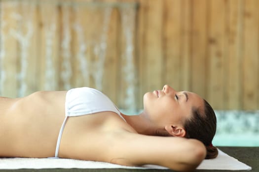 Side view portrait of a woman relaxing lying in the floor of spa