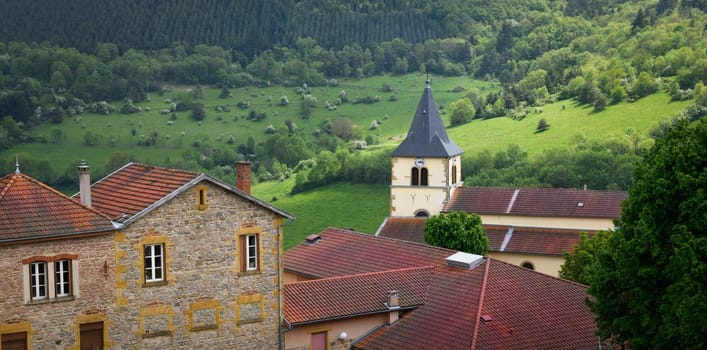 Typical village in the french countryside by spring with green grass and natural hills