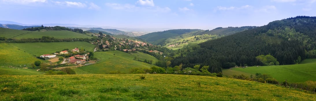 Typical village in the french countryside by spring with green grass and natural hills