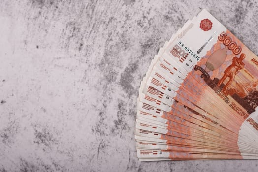 Russian money banknotes of five thousand rubles, background, banknotes are arranged in a fan on a gray background. Layout, mockup.