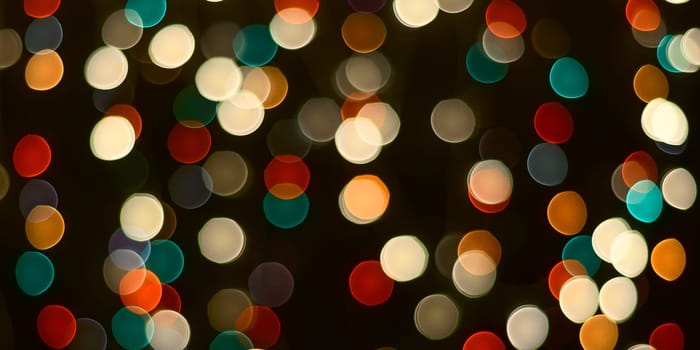 Festive background. A dark table and blurry multicolored lights in the background.