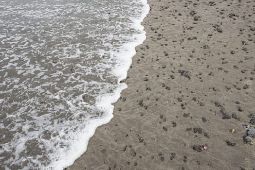 Rocky beach Sea Foam laps the shore