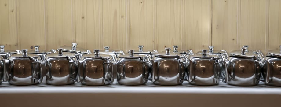 Many coffee pots stand side by side in one compartment.