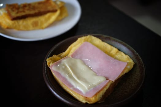 Sandwiches with egg, ham and toast cheese fried in dish