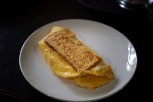 Sandwiches with egg, ham and toast cheese fried in white dish