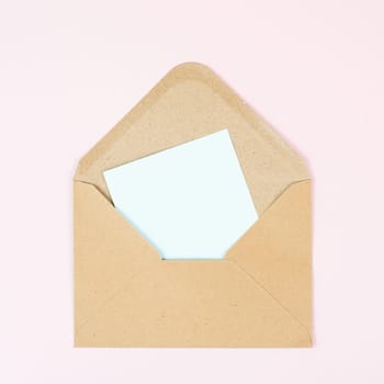 Envelope with an empty paper on a rose colored background, copy space for text, greeting card, communication and announcement concept, reminder