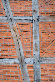 Old wall made of brown half-timbered, bricked with bricks in different shades