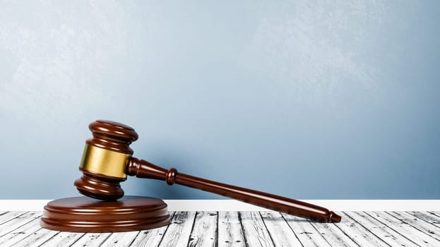Judge's Gavel on Wooden Floor Against Blue Wall with Copy Space 3D Render Illustration