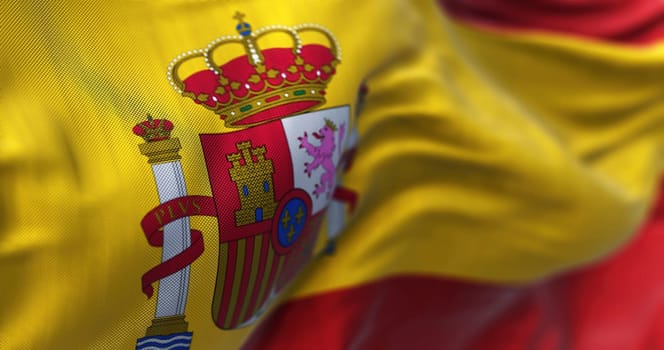 Close-up view of Spain national flag waving in the wind. Spain is a country in southwestern Europe. Fabric background