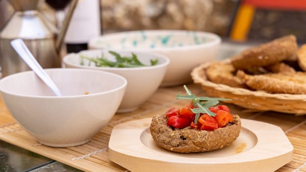 Italian summer appetizer Friselle with cherry tomatoes, oil and rucola served outdoor with glasses of red wine. Tipical Apulian Dried bread, made in Salento. Local cousine. Vegetarian food