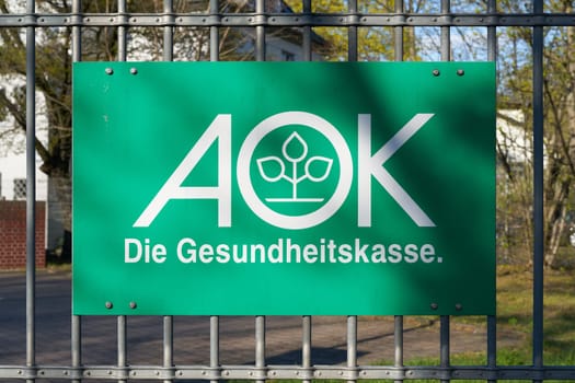 Sign on a fence of a branch of the health insurance company AOK in Wittenberg