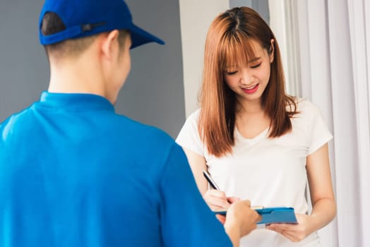 Asian beautiful customer young woman signing delivery in clipboard get her package from service courier man, smiling female signature receipt of delivery package at door front house