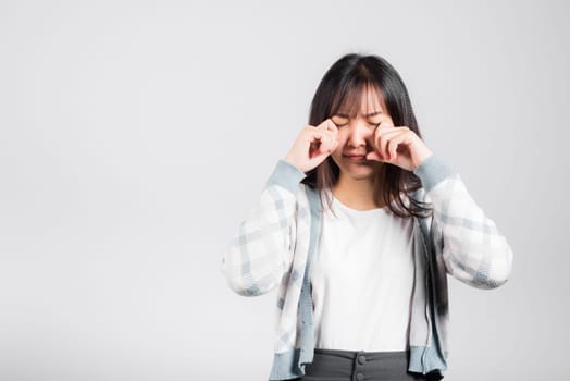 Unhappy woman bad mood her cry wipe tears with fingers, Asian beautiful young female stress feeling sad unhappy crying, studio shot isolated on white background with copy space