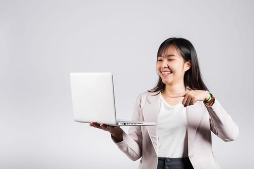 Woman teen smiling confident smiling face holding using laptop computer and pointing finger to screen, Portrait excited Asian young female person businesswoman studio shot isolated on white background