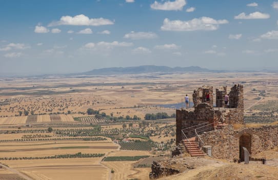 Visitors observing La Serena landscape from Magacela fostress remains, Badajoz, Extremadura, Spain. Origin of the fortress was believed pre-Roman