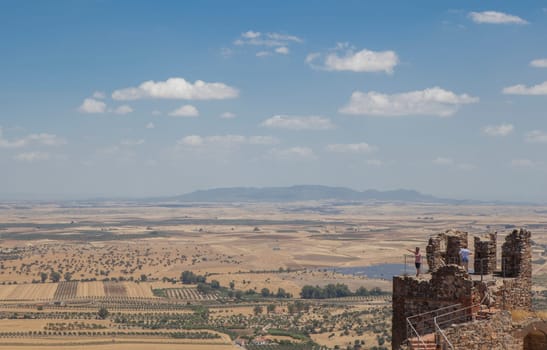 Visitors observing La Serena landscape from Magacela fostress remains, Badajoz, Extremadura, Spain. Origin of the fortress was believed pre-Roman
