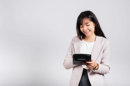 Tax day concept. Woman confident smiling holding electronic calculator, Portrait excited happy Asian young female studio shot isolated on white background, Business Account and finance counting income