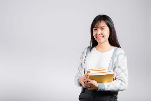 Woman teen smiling holding and hug embrace favorite book for lover, Portrait of beautiful Asian young female person teacher studio shot isolated on white background, education concept
