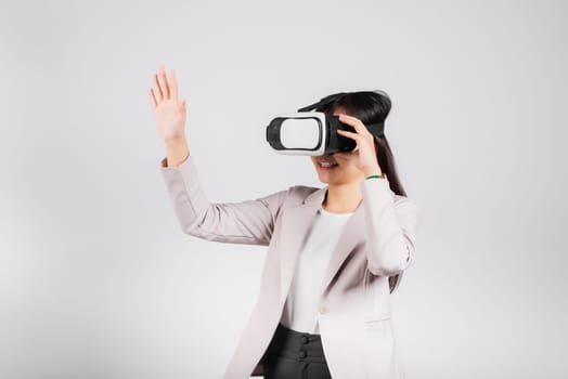 Smiling woman confidence excited wear VR headset device touching air during virtual reality experience isolated white background, Asian happy portrait female playing video game studio shot, copy space