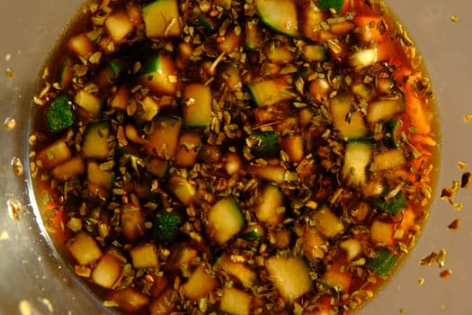 Soy sauce in a glass bowl with some vegetables