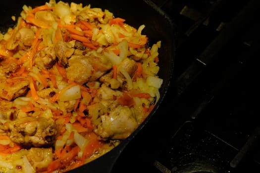 Homemade Korean Spicy chiken dish, frying chiken with carrot in a pan with sunflower oil