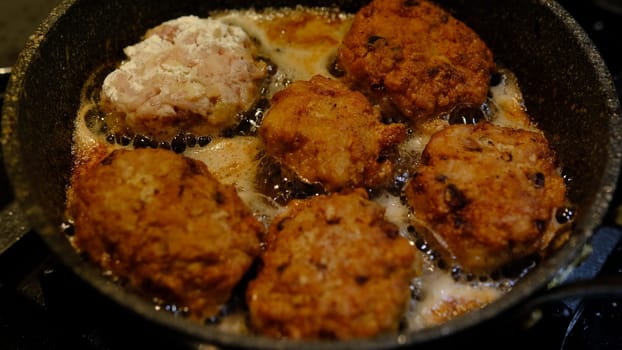 The process of cooking and roasting beef meat cutlets in a frying pan in a sunflower oil.
