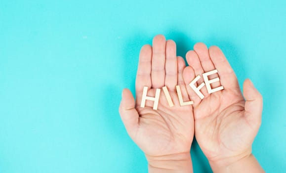 Holding the word help in the hands, german language, giving support and charity