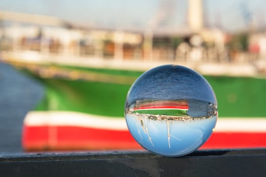 Fishing boats and old quays with the city view through lensball