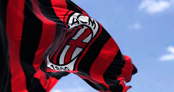 Milan, Italy, July 2022: The flag of A.C. Milan waving in the wind on a clear day. Milan is a professional football club based in Milan, Italy