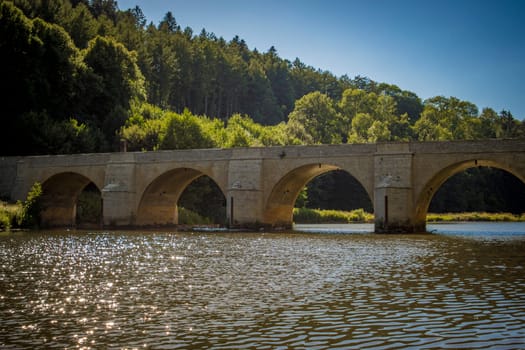 View on the historical Saint-Nicolas bridge over river Semois in Chiny in the province of Luxembourg, Belgium
