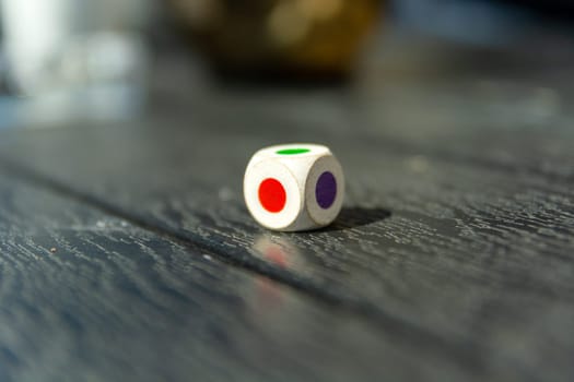 Dice with colored dots on the table, close up