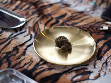 Medical marijuana flower buds. Recreational marijuana strain. Cannabis strain. Weed bud in brass dish.
