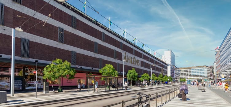 Stockholm, Sweden - June 25 2022: Norrmalm district in central Stockholm, with the famous Swedish department store, Ahlens, few pedestrians, and low traffic, in a sunny summer day