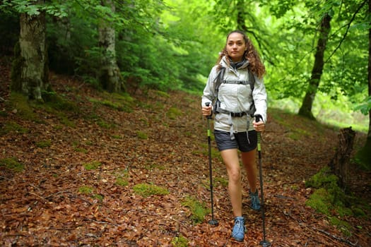Front view portrait of a hiker walking in a deep forest