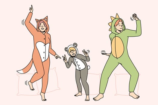 People in kigurumi pajamas have fun dancing indoors. Smiling adults and kid enjoying pyjama home party together. Leisure weekend. Vector illustration.