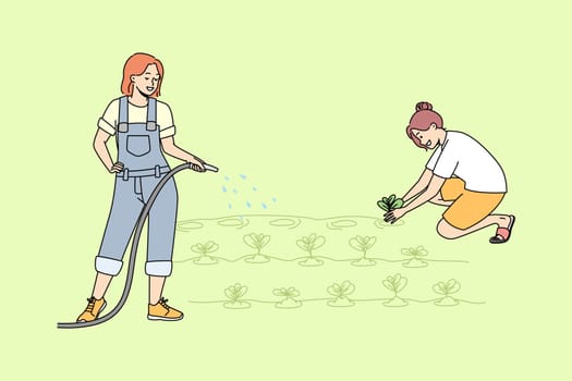 Young women working in garden watering plants together. Female cartoon characters involved in farming or agriculture at plantation. Vector illustration.