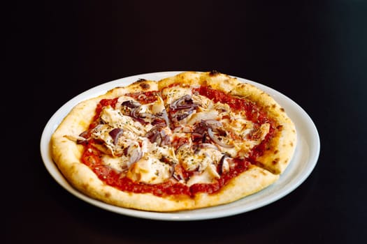 Close look to fresh pizza with tomato sauce, chicken and red onion