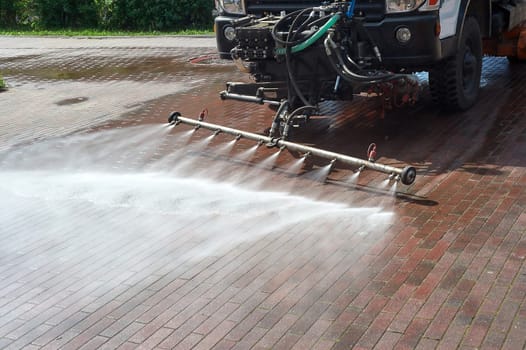 A special machine washes city paths and roads with water. High quality photo