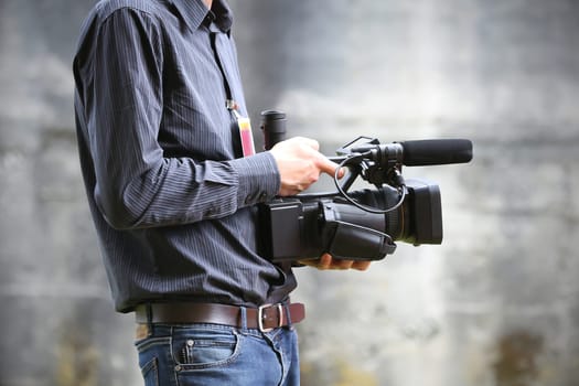 Video camera man with camera on gray background