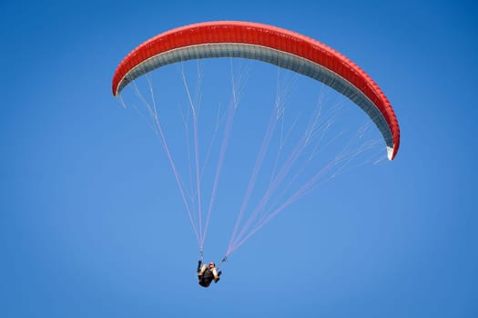 Paraglider, airborne in a clear blue sky