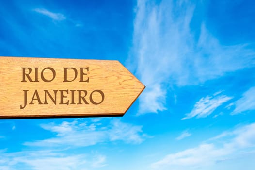 Wooden arrow sign pointing destination RIO DE JANEIRO against clear blue sky with copy space available. Travel destination conceptual image