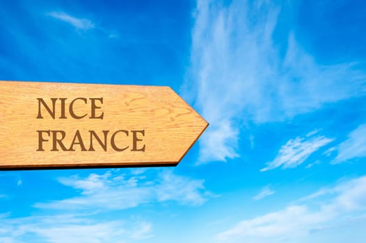 Wooden arrow sign pointing destination NICE, FRANCE  against clear blue sky with copy space available. Travel destination conceptual image
