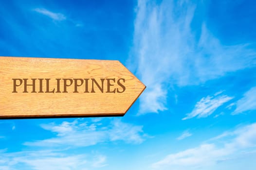 Wooden arrow sign pointing destination PHILIPPINES against clear blue sky with copy space available. Travel destination conceptual image