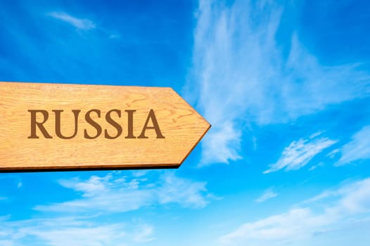 Wooden arrow sign pointing destination RUSSIA against clear blue sky with copy space available. Travel destination conceptual image