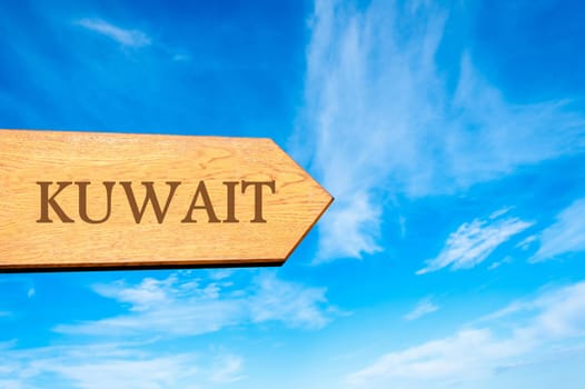 Wooden arrow sign pointing destination KUWAIT against clear blue sky with copy space available. Travel destination conceptual image