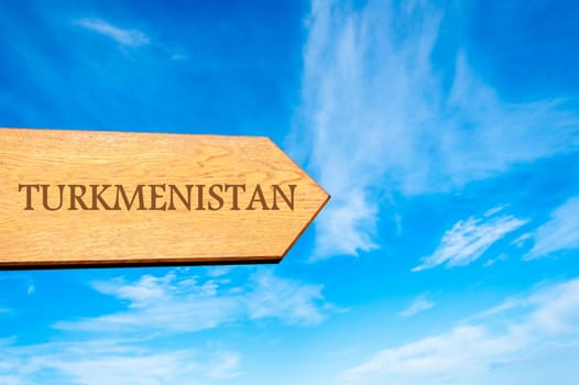 Wooden arrow sign pointing destination TURKMENISTAN against clear blue sky with copy space available. Travel destination conceptual image