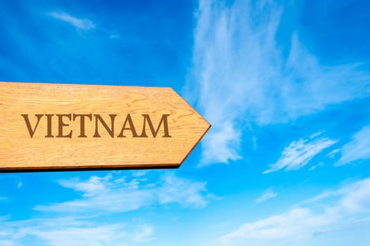Wooden arrow sign pointing destination VIETNAM against clear blue sky with copy space available. Travel destination conceptual image
