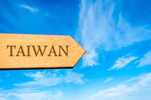 Wooden arrow sign pointing destination TAIWAN against clear blue sky with copy space available. Travel destination conceptual image