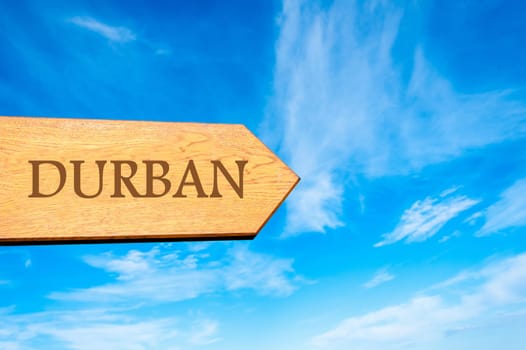 Wooden arrow sign pointing destination DURBAN against clear blue sky with copy space available. Travel destination conceptual image