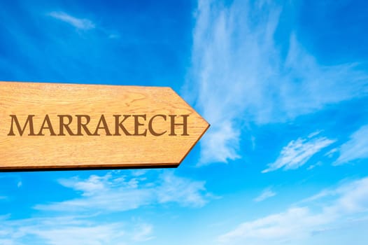 Wooden arrow sign pointing destination MARRAKECH  against clear blue sky with copy space available. Travel destination conceptual image